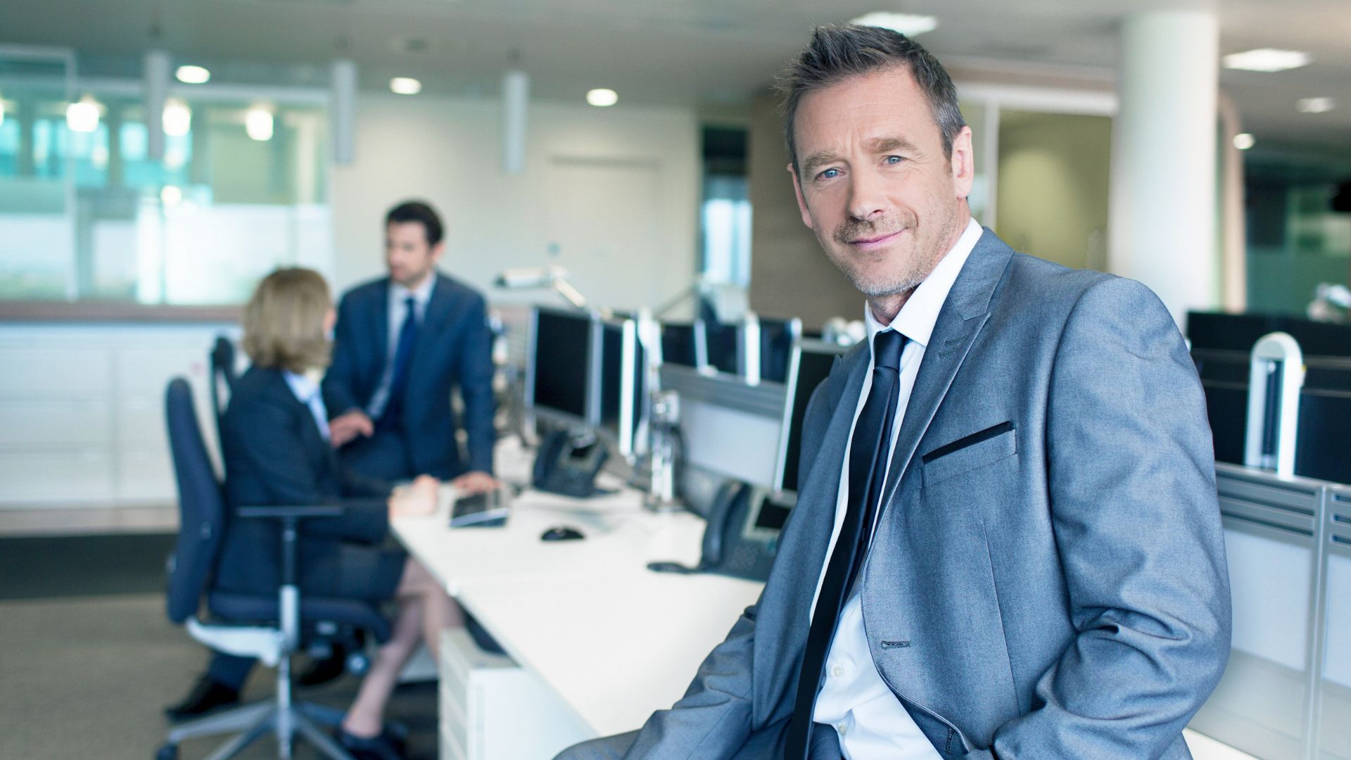 Homme d'affaires souriant en costume au bureau.