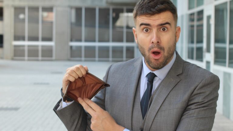 Homme d'affaires surpris avec portefeuille vide.