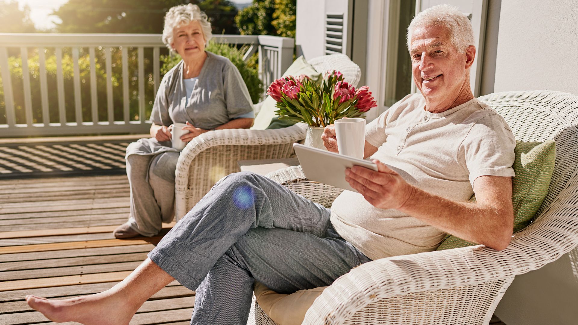 Couple âgé se détendant sur leur terrasse ensoleillée.