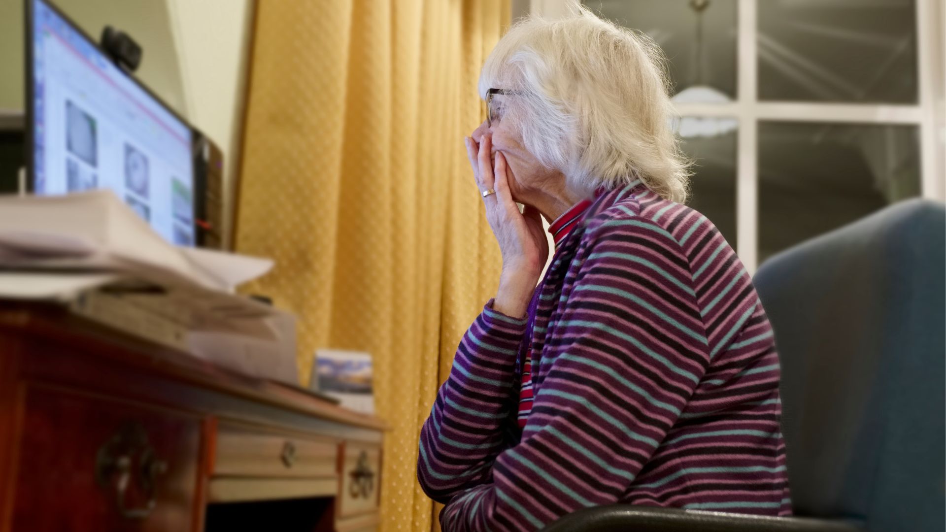 Personne âgée utilisant un ordinateur à domicile.