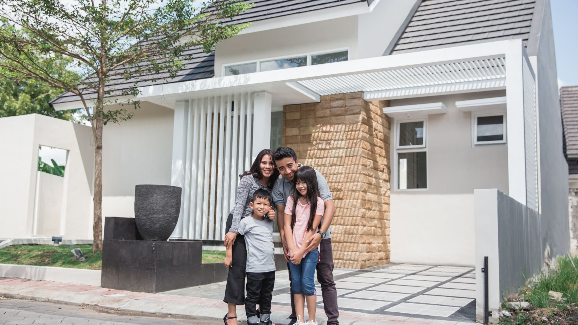 Famille heureuse devant nouvelle maison moderne