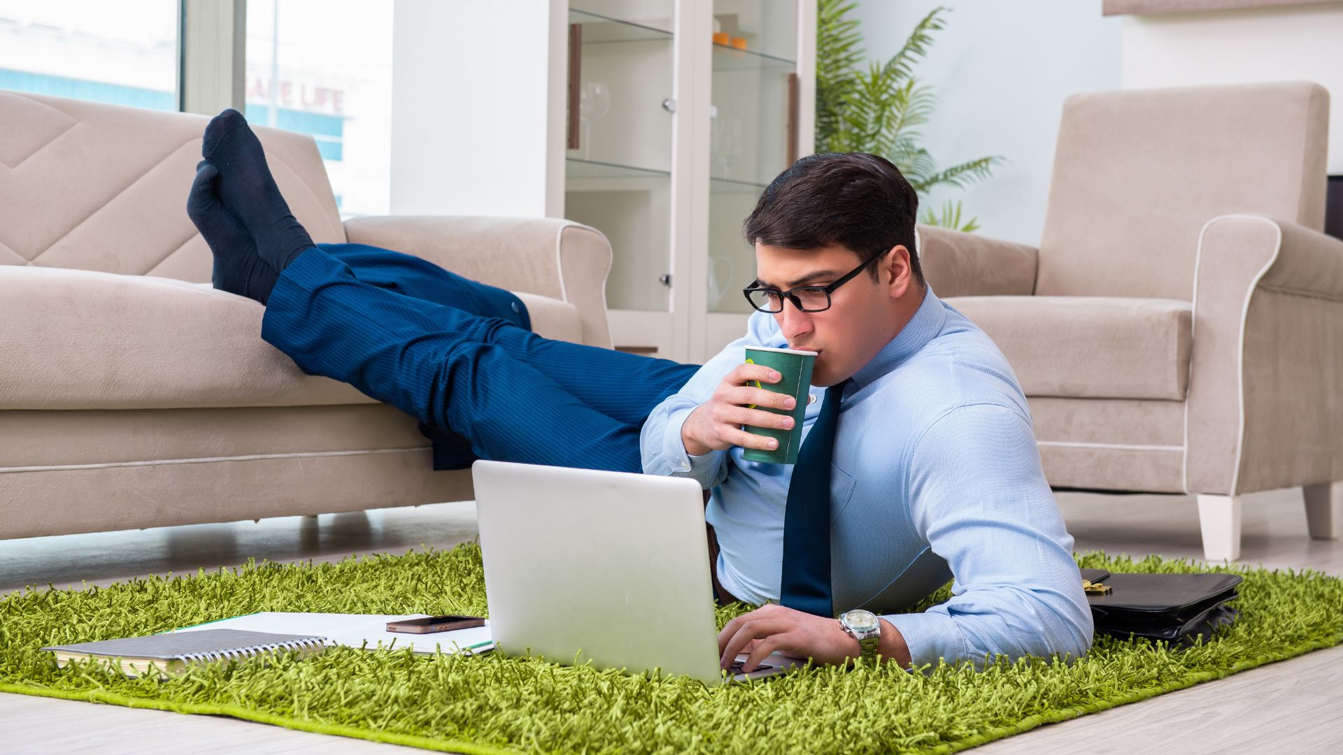 Homme travaillant détendu avec ordinateur et café.