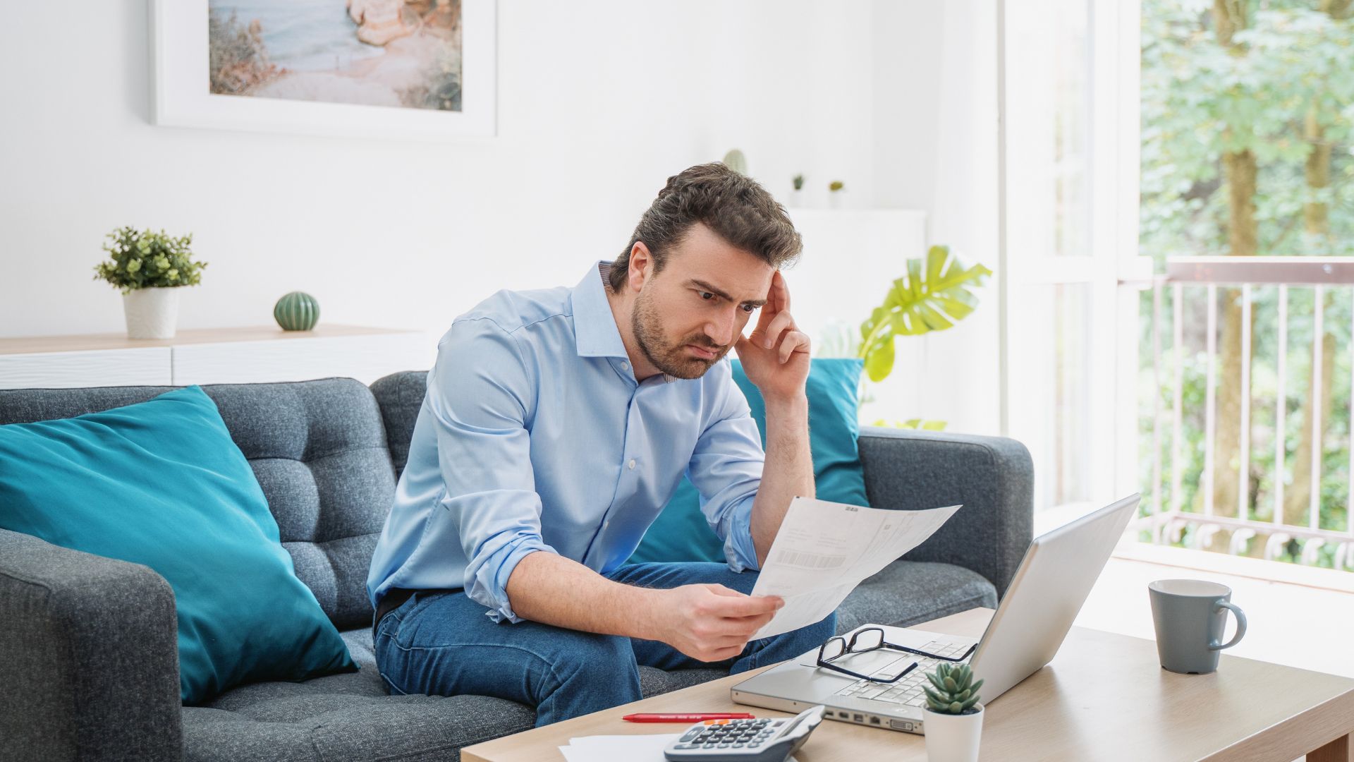 Homme travaillant de chez lui, concentration et paperasse.