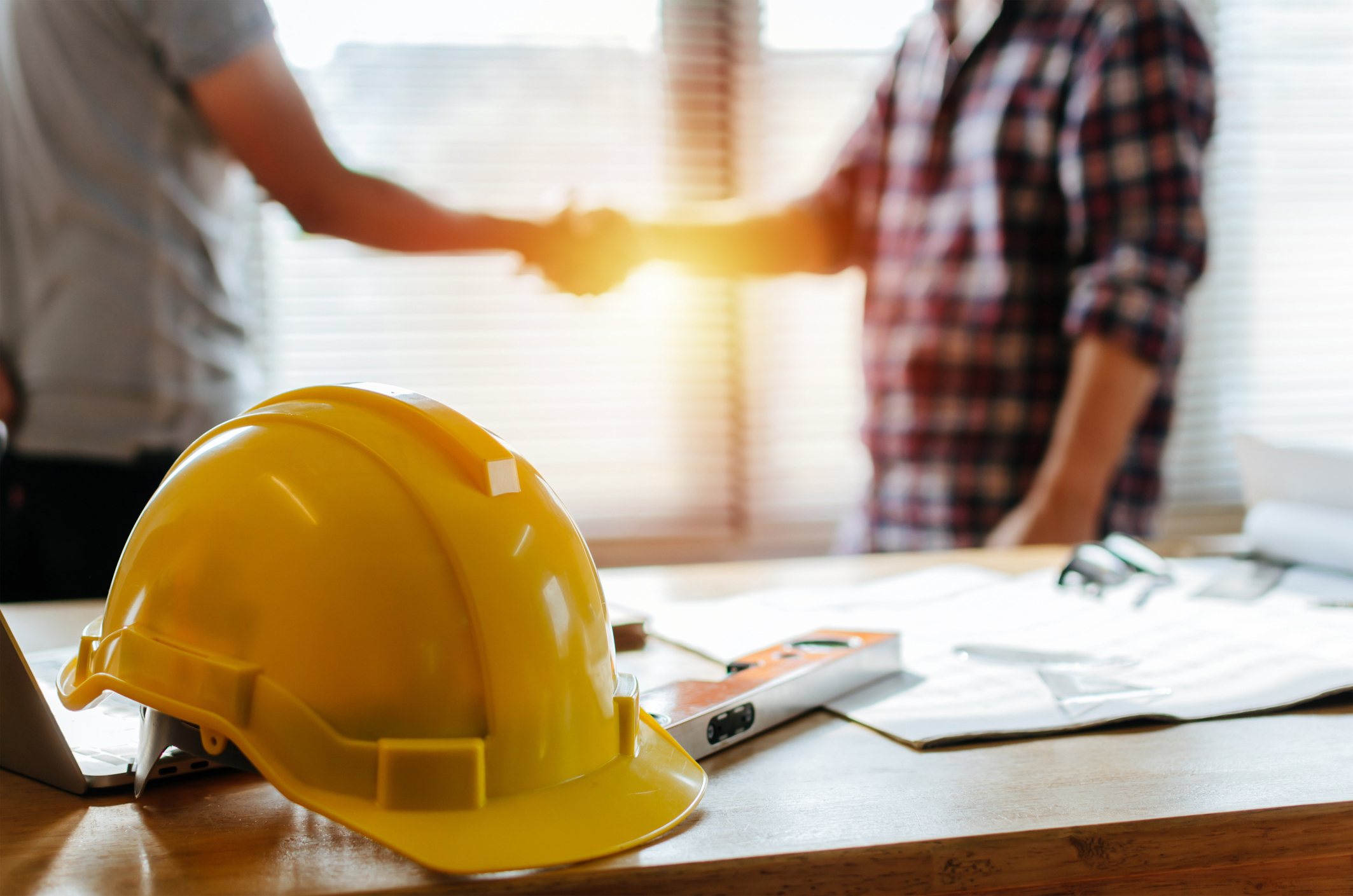 Poignée de main sur chantier avec casques de sécurité