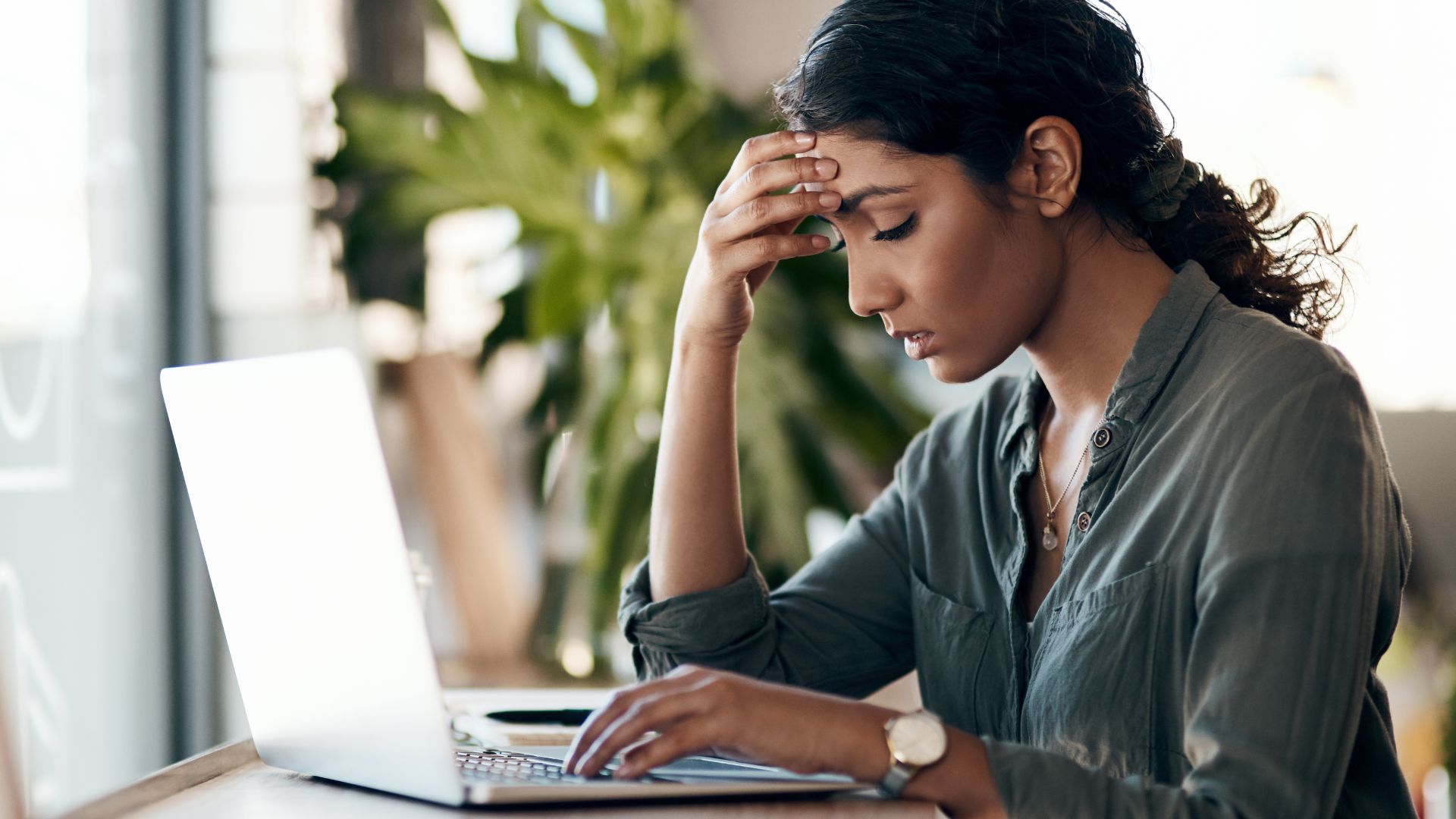 Femme stressée travaillant sur ordinateur.