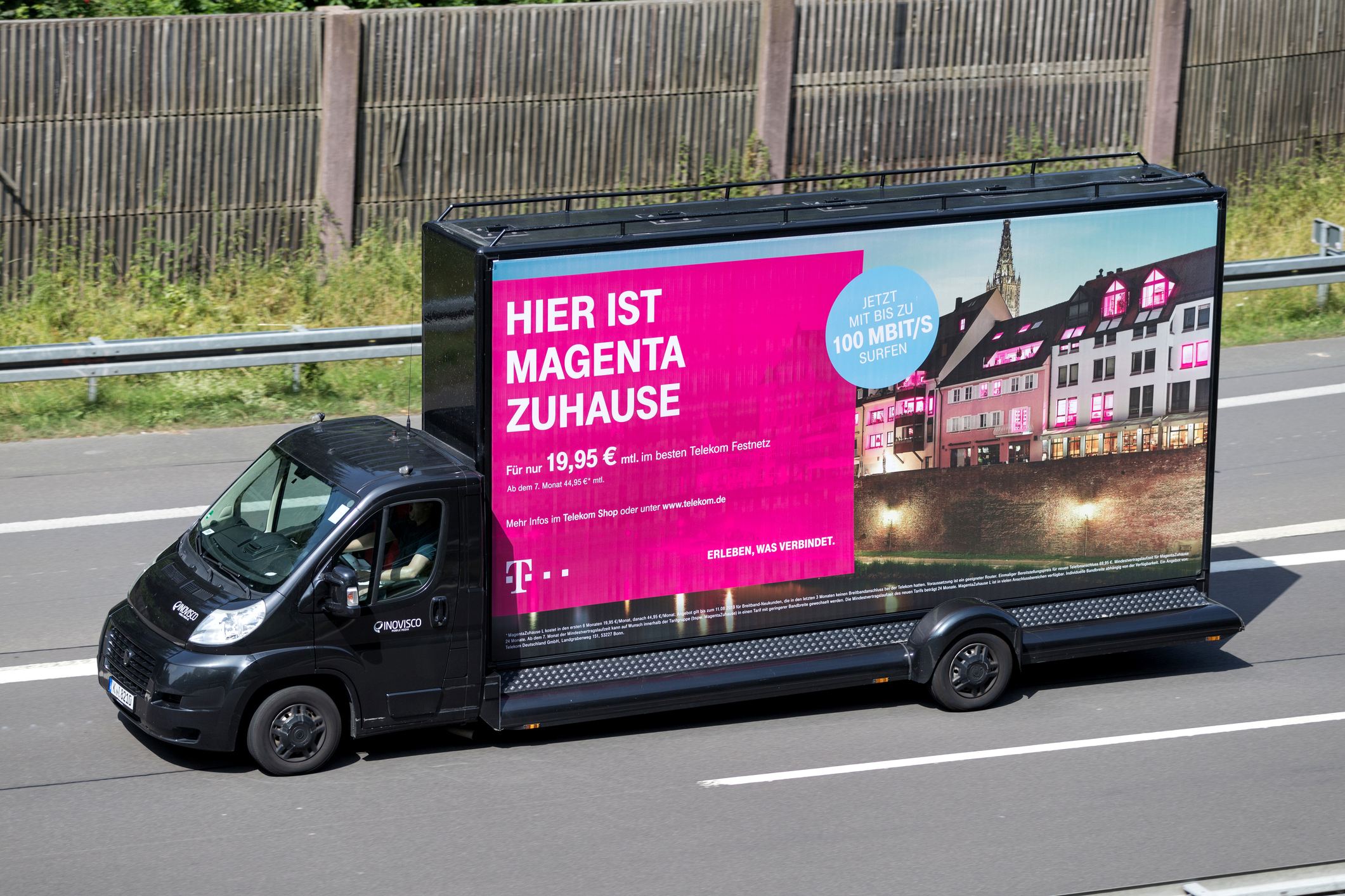 Camion publicitaire sur autoroute en journée.